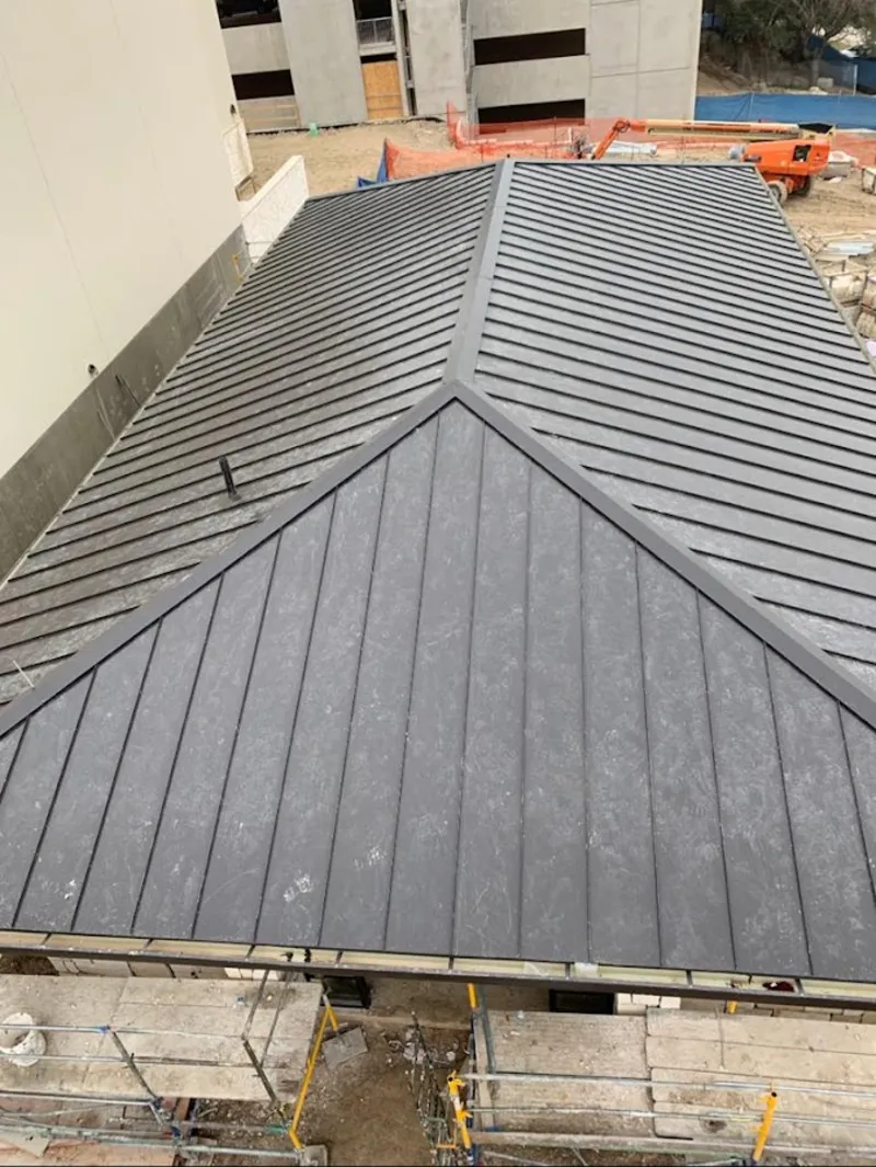 Commercial metal roof construction with crane equipment in Cumberland